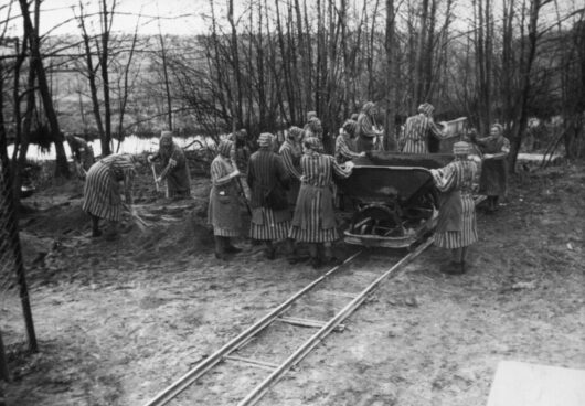 Vrouwelijke gevangenen laden vrachtwagens in concentratiekamp Ravensbrück